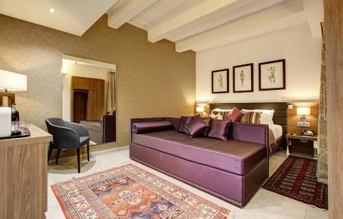 a living room with a purple couch and a bed at Palazzo Paolina Boutique Hotel in Valletta