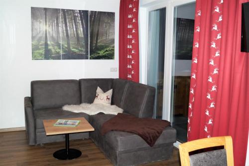a living room with a couch and a table at Sieglhub Chalets - Appartements - Hotel in Flachau