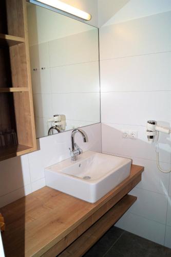 a bathroom with a white sink and a mirror at Sieglhub Chalets - Appartements - Hotel in Flachau