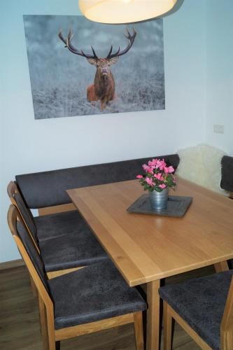 a dining room table with a deer head on the wall at Sieglhub Chalets - Appartements - Hotel in Flachau