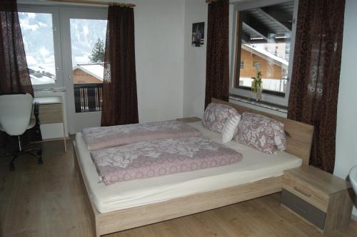 フューゲンにあるSchiestlhofの大きな窓付きの客室のベッド1台分です。