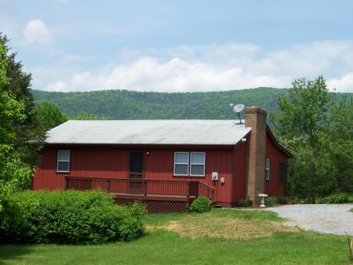 czerwony dom z gankiem i dachem w obiekcie Bear Bluff w mieście Rileyville