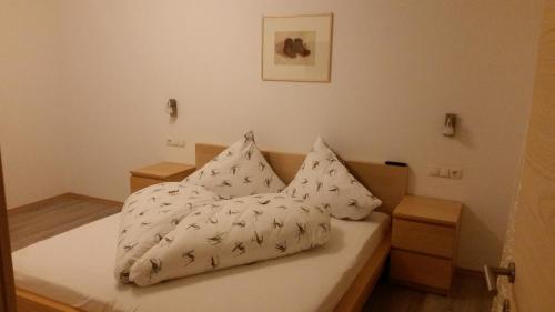 ein Bett mit zwei Kissen auf einem Zimmer in der Unterkunft Haus Elisabeth in Pfunds