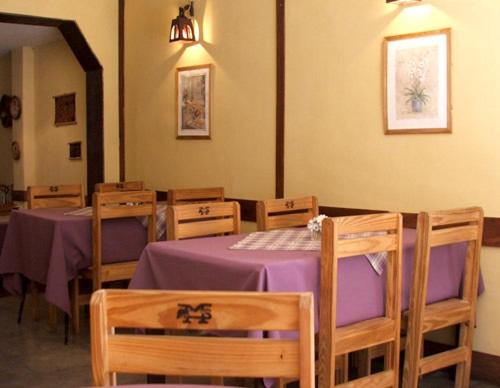 una habitación con mesas y sillas con mantel púrpura en Hostería Las Gemelas en Capilla del Monte