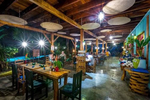 a restaurant with wooden ceilings and tables and chairs at Hotel Banana Azul - Adults Only in Puerto Viejo