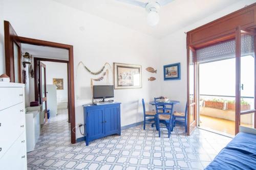 una camera da letto con armadio blu e tavolo con televisore di ISCHIA - PANORAMIC APARTMENT ON THE SEA a Ischia