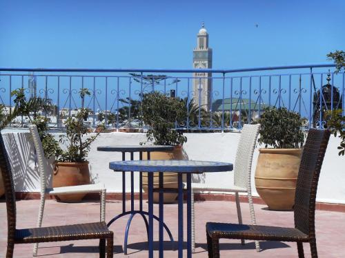 a patio area with chairs, tables, and a clock at Hôtel Central in Casablanca