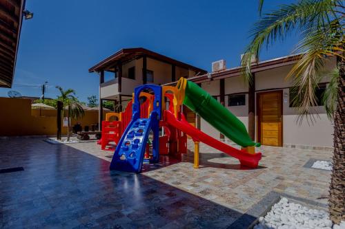 un parco giochi con scivolo di fronte a un edificio di Pousada Chalés do Julião a Ubatuba