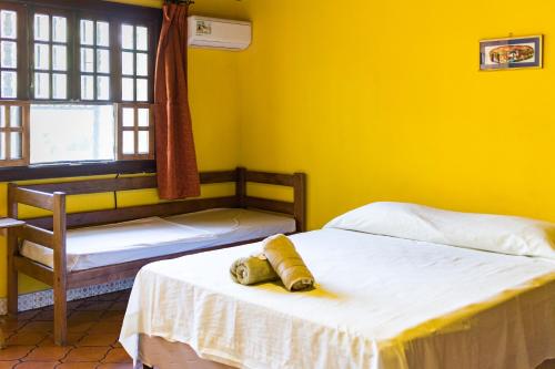 two beds in a room with yellow walls at Casa Inti Guesthouse & Lodge in Managua