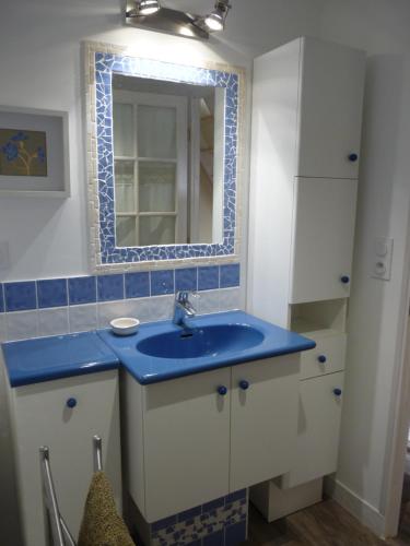 y baño con lavabo azul y espejo. en L'Etable d'Orgerus, en Orgerus