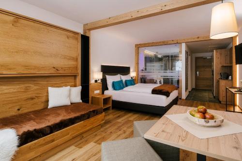 Un dormitorio con una cama y una mesa con un bol de fruta en Bergresort Das Jochelius en Nauders