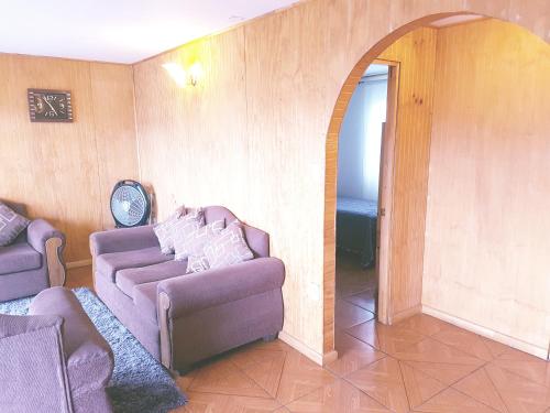a living room with a purple couch and an archway at Cabaña Tongariki in Hanga Roa