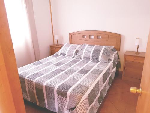 a bedroom with a bed with a striped bedspread at Cabaña Tongariki in Hanga Roa