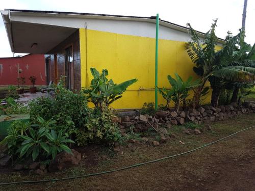 a yellow and white building with plants in front of it at Cabaña Tongariki in Hanga Roa