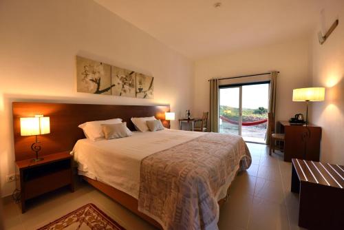 1 dormitorio con cama grande y ventana grande en Quinta das Ratoeiras, en Vidigueira