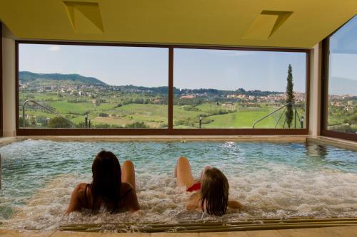 three women laying in a swimming pool in a house at Agriturismo Palazzo Bandino - Wine cellar, on reservation restaurant and spa in Chianciano Terme