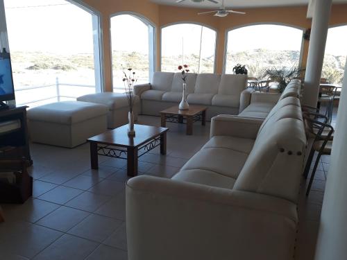 a living room with white couches and a tv at Hotel Colonos in Las Grutas