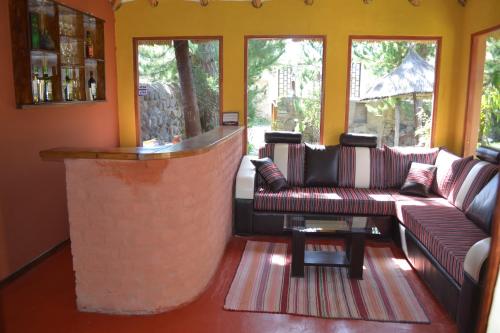 a lobby with couches and a bar with windows at Miskiwasi Bed & Breakfast in Yanque