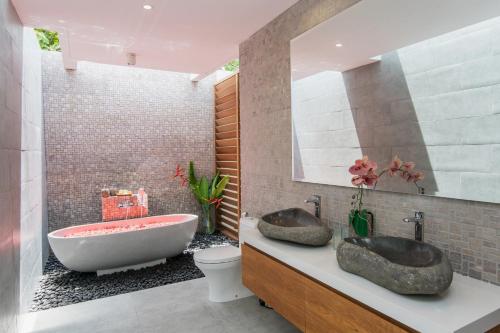 a bathroom with two sinks and a bath tub at Villa Kobe Beachside Berawa Canggu location in Canggu