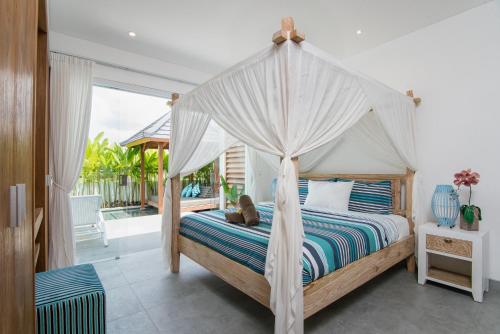 a bedroom with a bed with a canopy at Villa Kobe Beachside Berawa Canggu location in Canggu