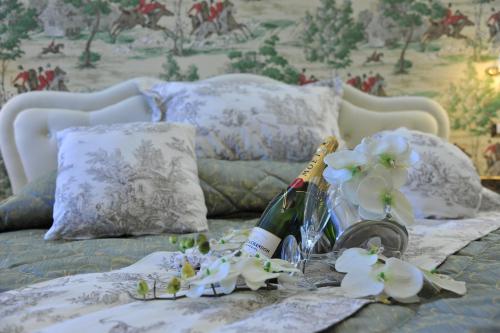 a bed with a bottle of wine and flowers on it at B&b Le Cycas in Castellammare di Stabia