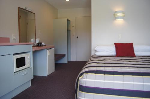 a hotel room with a bed and a kitchen at Heritage Park Lodge in Haast