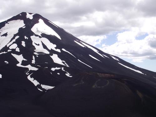 a snow covered mountain with a cloudy sky in the background at Refugio Las Raices in Malalcahuello