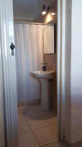 a white bathroom with a sink and a shower at Apartamentos del Este in Piriápolis