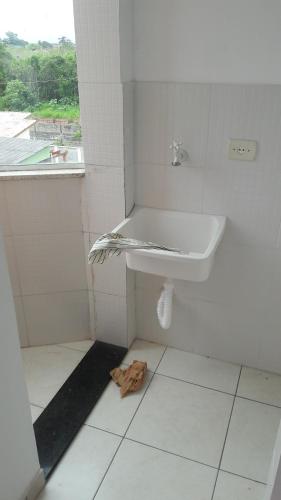 a bathroom with a sink and a towel on the floor at Itanhaém flat residence in Itanhaém