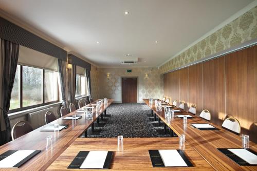 a large conference room with long tables and chairs at Dalziel Park Hotel in Motherwell