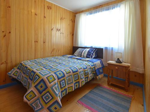 a bedroom with a bed and a window at Cabaña en barrio Palafitos de Castro in Castro