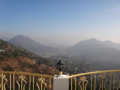 a street light on a balcony with mountains in the background at Aqua De Vida in Bhowāli