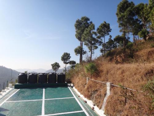 a tennis court sitting on top of a hill at Aqua De Vida in Bhowāli