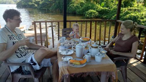 a group of people sitting at a table eating food at Mahi Villa in Bentota