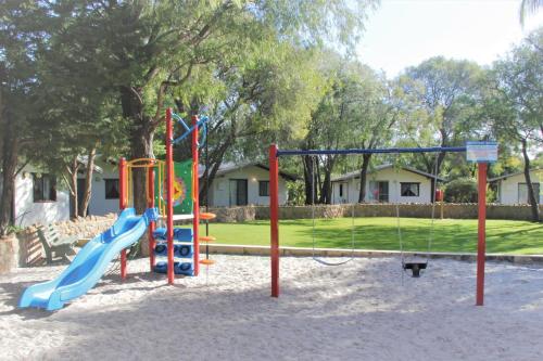 a playground with a slide in the sand at Sandy Bay Holiday Park in Busselton