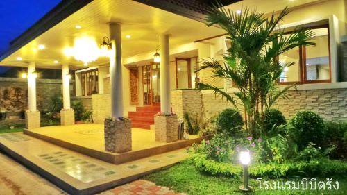 a house with a palm tree in front of it at BB Trang Hotel in Trang