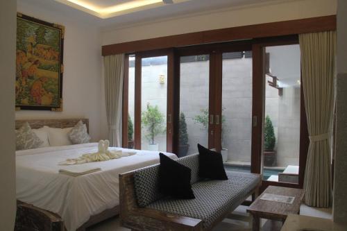 a bedroom with a bed and a large window at Green Studio Apartment Seminyak in Seminyak