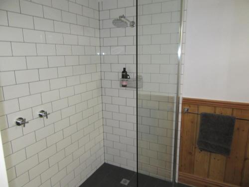 a bathroom with a shower with white tiled walls at Nivani 1880's cottage in Port Fairy