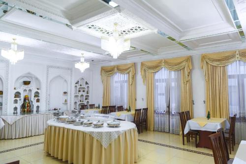 a dining room with tables and chairs in a building at Siyavush in Bukhara