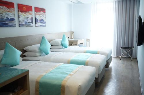 a group of three beds in a room at Palau Hotel in Koror