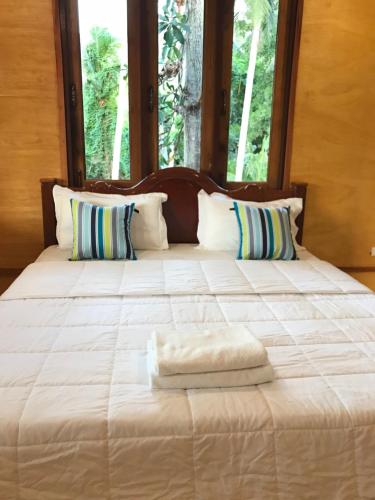 a large white bed with two towels on it at Kiri Tawan in Baan Tai