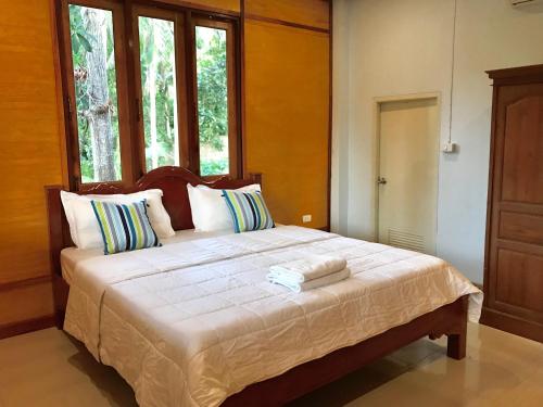 a bedroom with a large bed with two towels on it at Kiri Tawan in Baan Tai