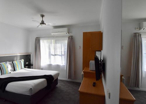 a hotel room with a bed and a window at Ballina Homestead Motel in Ballina