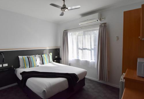 a hotel room with a bed and a window at Ballina Homestead Motel in Ballina