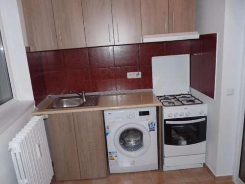 a small kitchen with a washing machine and a sink at Apartament Rema in Constanţa