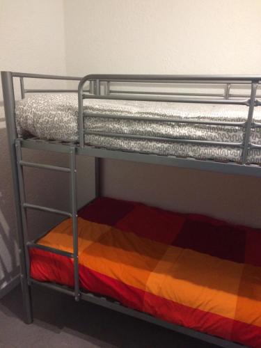 a bunk bed with a multi colored blanket on it at Résidence les dromadaires in Gruissan