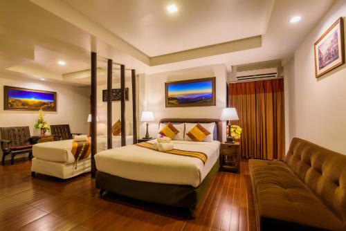 a hotel room with a bed and a couch at Panna Heritage Boutique Hotel - SHA Plus in Chiang Mai