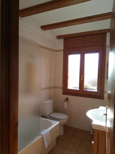 a bathroom with a tub and a toilet and a sink at Casa la Era in Nogueruelas