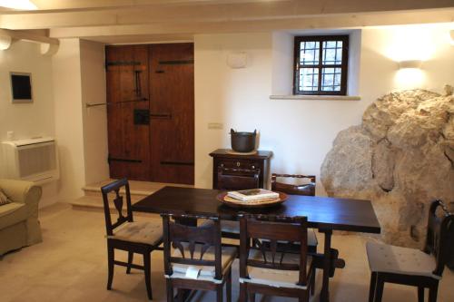 - une salle à manger avec une table, des chaises et un grand rocher dans l'établissement Holiday home Villa Vanya, à Mali Ston