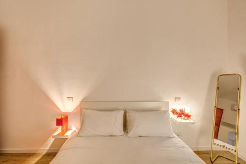 ローマにあるRhome Apartments Candiaのベッドルーム(白いベッド1台、鏡付)
